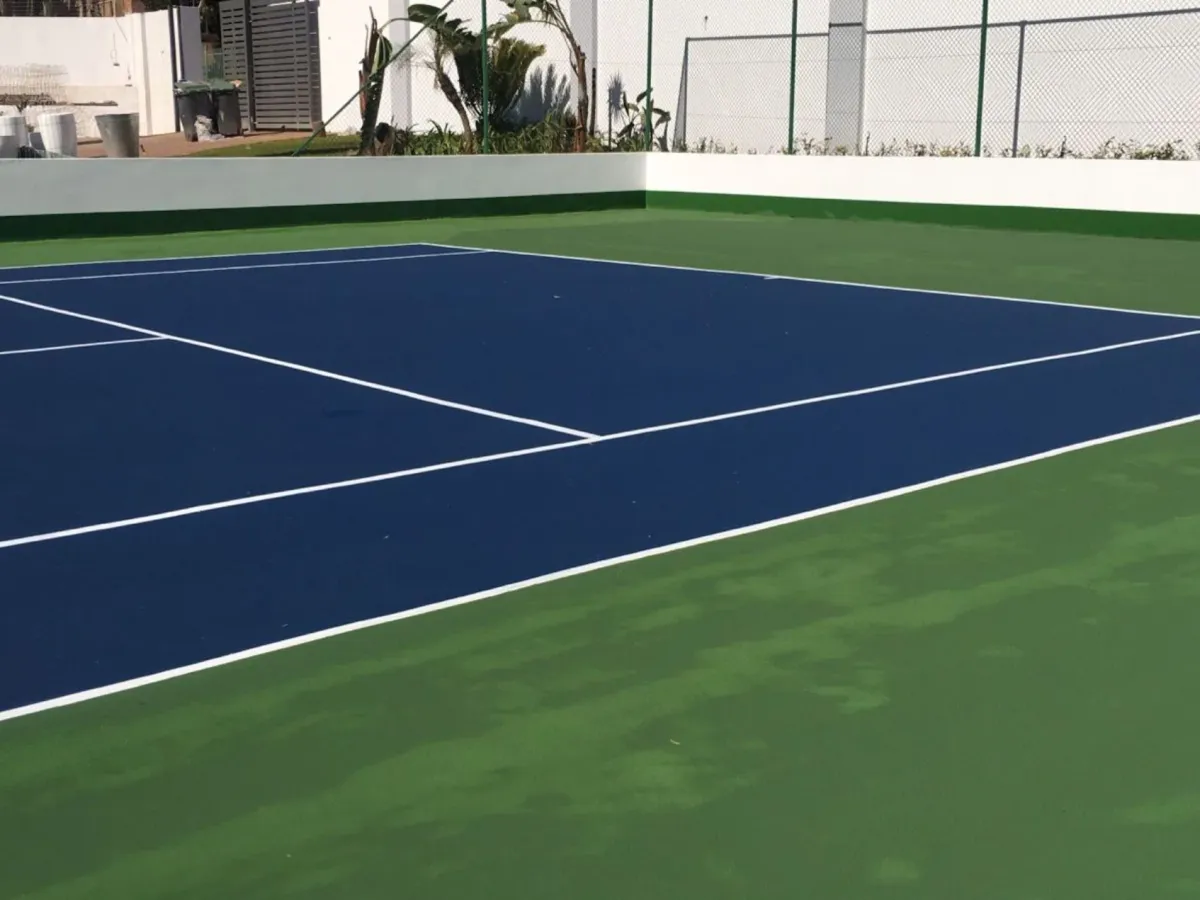 Newly resurfaced blue and green hard-surface tennis court with crisp white lines, built by Real Tennis Court